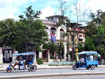 Imagen del 18 de junio de 2026 de pasajeros viajando a bordo de triciclos eléctricos por una avenida en La Habana, Cuba. XINHUA/J. Hernández