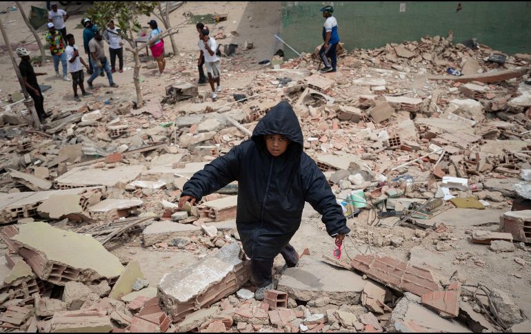 Un niño camina este jueves, entre los escombros de edificios afectados por los terremotos en La Guaira, Venezuela. EFE/ R. Peña