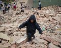 Un niño camina este jueves, entre los escombros de edificios afectados por los terremotos en La Guaira, Venezuela. EFE/ R. Peña