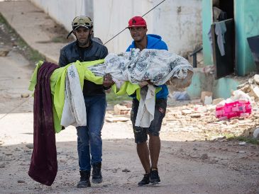 Voluntarios rescatan víctimas mortales este jueves, en Catia La Mar. EFE/R. Peña