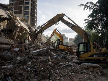 Integrantes de equipos de rescate trabajan en un edificio afectado por un terremoto en Caracas. EFE / B. Vergara
