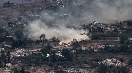 Maniobras de tanques israelíes mientras un convoy de la Fuerza Provisional de las Naciones Unidas en el Líbano (FPNUL) circula entre casas destruidas en la aldea de Meiss El Jabal, en el sur del Líbano, visto desde el lado israelí de la frontera en la Alta Galilea, el 26 de junio de 2026. EFE/A. SAFADI