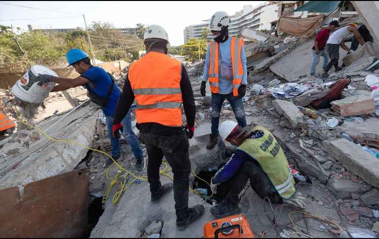 Integrantes de equipos de rescate realizan una búsqueda en los escombros de un edificio este lunes, en La Guaira Venezuela. EFE/ R. Peña