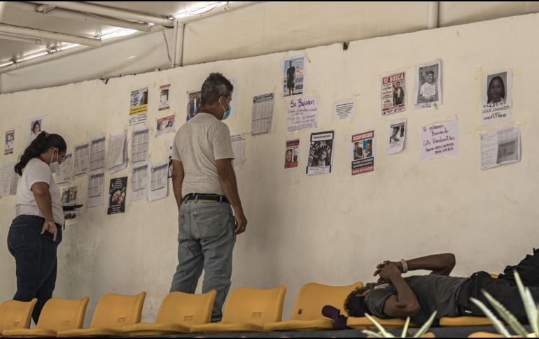 Personas observan listas y fotografías de personas desaparecidas en los terremotos, este lunes, en un puerto en La Guaira, Venezuela. EFE/ Henry Chirinos