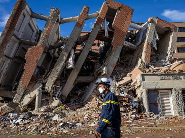 Un rescatista de Vietnam camina este martes frente a escombros de edificaciones destruidas en Catia La Mar, La Guaira, Venezuela. EFE/ M. Gutierrez