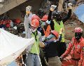 Rescatistas, entre ellos los Topos Azteca, piden silencio a los presentes tras haber escuchado sonidos bajo los escombros de un edificio. EFE
