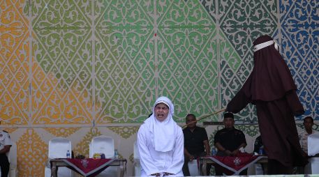 Una mujer de Aceh reacciona a los azotes durante un castigo público por violar la ley islámica en Banda Aceh, Indonesia, el 2 de julio de 2026; el Tribunal de la Sharía y la Fiscalía de Banda Aceh castigaron a los infractores con entre 10 y 30 azotes, incluyendo a una pareja que fue sorprendida besándose en directo en la plataforma TikTok. EFE/H. SIMANJUNTAK