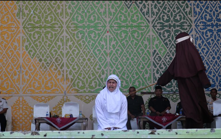 Una mujer de Aceh reacciona a los azotes durante un castigo público por violar la ley islámica en Banda Aceh, Indonesia, el 2 de julio de 2026. El Tribunal de la Sharia y la Fiscalía de Banda Aceh castigaron a los infractores con entre 10 y 30 azotes, incluyendo a una pareja que fue sorprendida besando a sus parejas en directo en la plataforma TikTok. EFE/H. SIMANJUNTAK
