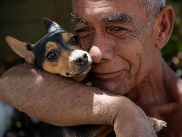 Un hombre abraza a su perro rescatado de los escombros de un edificio afectado por los terremotos, este miércoles, en La Guaira, Venezuela. EFE/ R. Peña