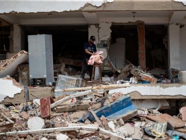 Una persona busca pertenencias en medio de los escombros de un edificio este domingo, en La Guaira, Venezuela. EFE/ R. Peña