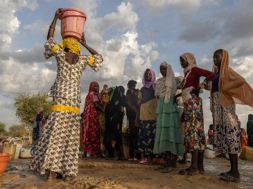Mujeres y niños recogen agua al atardecer en el campamento de refugiados de Korsi en Birao, República Centroafricana, el 27 de marzo de 2026. AP/C. Kelly