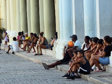 Imagen del 14 de julio de 2026 de personas sentadas en el portal de un edificio durante una desconexión del Sistema Electroenergetico Nacional (SEN), en La Habana, capital de Cuba. Xinhua/J. Hernández