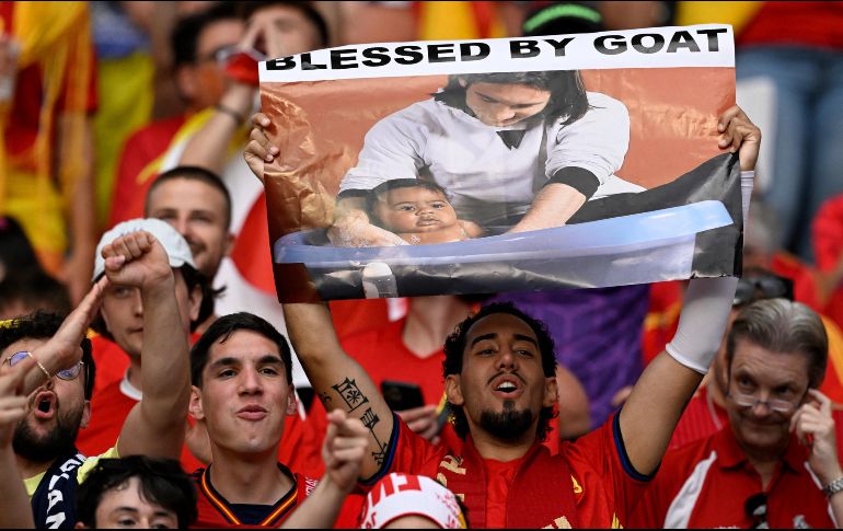 Un aficionado español sostiene un cartel con la foto del joven Messi y Yamal cuando éste aún era un bebé. AFP/AFP/I. Fassbender