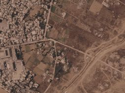 Imagen por satélite que muestra un tramo de una barrera de tierra construida por el ejército israelí, desde el lado derecho de la imagen y hacia abajo, en el centro de la Franja de Gaza, el 1 de julio de 2026. A la izquierda se ve el campo de refugiados de Maghazi, y al otro lado casas demolidas por el ejército. AP/Planet Labs PBC via AP)