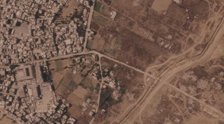 Imagen por satélite que muestra un tramo de una barrera de tierra construida por el ejército israelí, desde el lado derecho de la imagen y hacia abajo, en el centro de la Franja de Gaza, el 1 de julio de 2026. A la izquierda se ve el campo de refugiados de Maghazi, y al otro lado casas demolidas por el ejército. AP/Planet Labs PBC via AP)