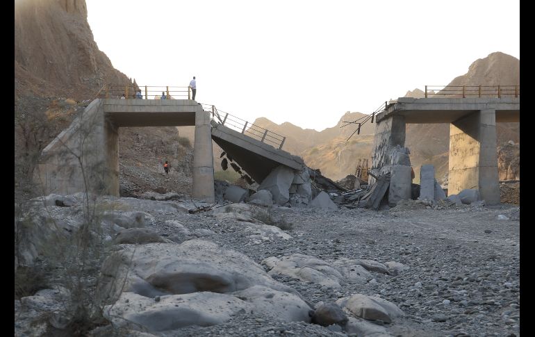Gente de pie en un puente destruido tras un ataque en lap provincia de Hormozgan, en el sur de Irán. AP/A. Khorgooi