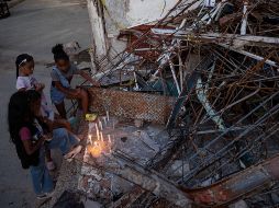 Personas encienden velas durante un homenaje a las víctimas por los terremotos del pasado 24 de junio, este viernes en Catia La Mar. EFE/R. Peña