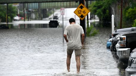Una persona camina a través de una inundación en Central Avenue cerca de la Interestatal 90. AP/W. Waldron