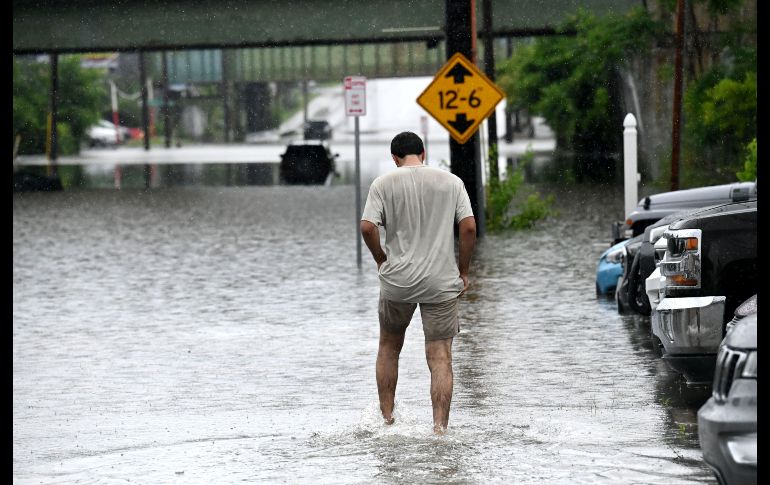 Una persona camina a través de una inundación en Central Avenue cerca de la Interestatal 90. AP/W. Waldron