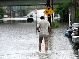 Una persona camina a través de una inundación en Central Avenue cerca de la Interestatal 90. AP/W. Waldron