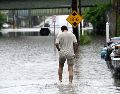 Una persona camina a través de una inundación en Central Avenue cerca de la Interestatal 90. AP/W. Waldron