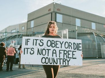 La pancarta que la manifestante sostiene expresa “si debemos elegir entre obedecer o morir, no es un país libre”. EFE