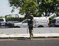 Un agente de la Policía Federal permanece junto a vehículos policiales cerca del lugar donde se halló el cuerpo del diputado Zenyazen Escobar García. AFP/V. Razo