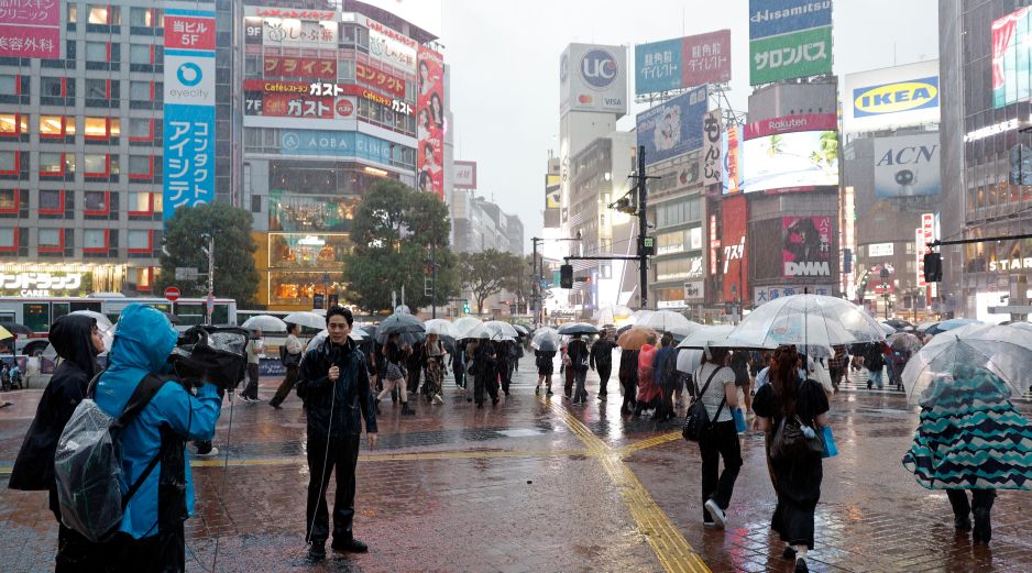 Un equipo de televisión realiza un reportaje cerca del cruce de Shibuya bajo las fuertes lluvias provocadas por el tifón Dujuan en Tokio, Japón, el 21 de septiembre de 2026. EFE/F. ROBICHON