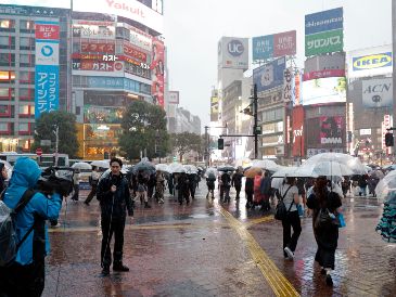 Un equipo de televisión realiza un reportaje cerca del cruce de Shibuya bajo las fuertes lluvias provocadas por el tifón Dujuan en Tokio, Japón, el 21 de septiembre de 2026. EFE/F. ROBICHON