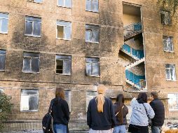 Un grupo de estudiantes en Kiev observa su escuela, impactada por drones rusos durante los últimos días. EFE