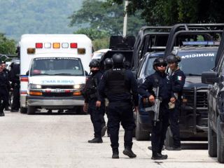 Integrantes de la policía vigilan afuera de las instalaciones del penal El Castillo este jueves luego de la riña que dejó 10 muertos. EFE/F. Mcconegly