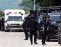 Integrantes de la policía vigilan afuera de las instalaciones del penal El Castillo este jueves luego de la riña que dejó 10 muertos. EFE/F. Mcconegly