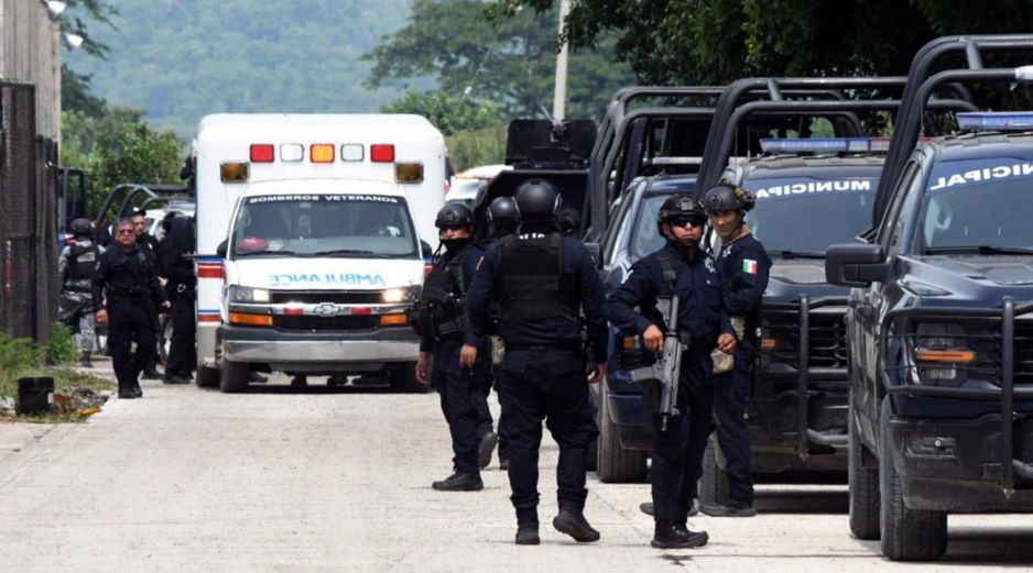 Integrantes de la policía vigilan afuera de las instalaciones del penal El Castillo este jueves luego de la riña que dejó 10 muertos. EFE/F. Mcconegly