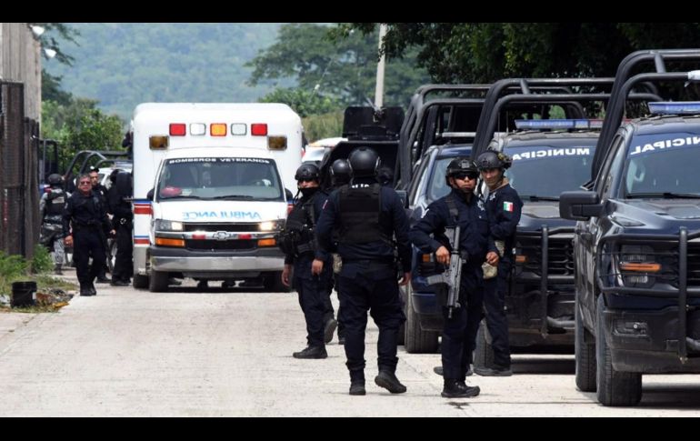 Integrantes de la policía vigilan afuera de las instalaciones del penal El Castillo este jueves luego de la riña que dejó 10 muertos. EFE/F. Mcconegly