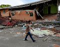 Un hombre camina cerca de una vivienda afectada el terremoto este sábado, en Tonosí, Panamá. EFE/B. Velasco